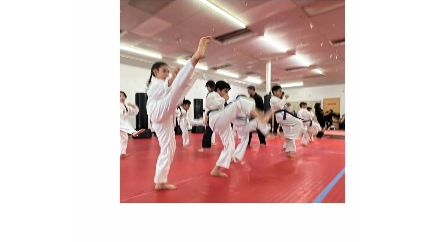 Legacy students practicing kicks as a group