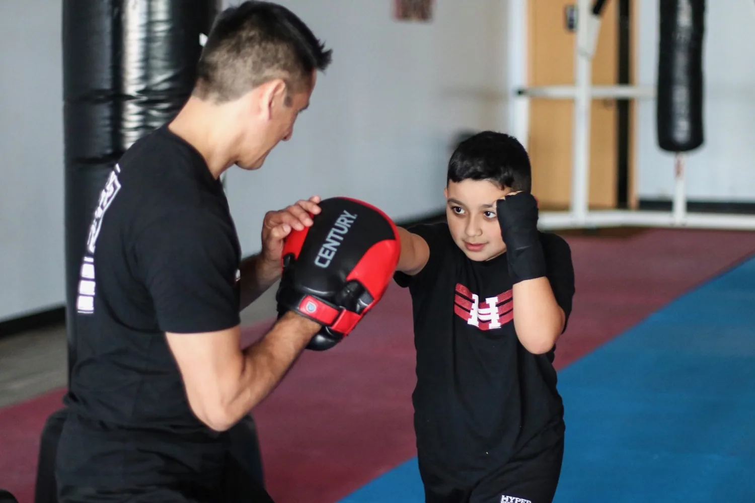 A Legacy student practicing with focus mitts and an instructor