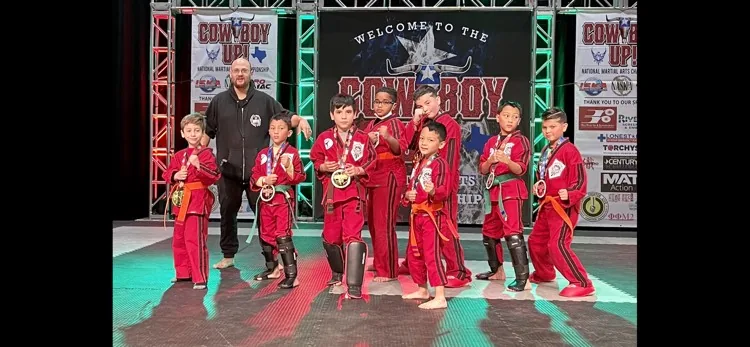 Legacy students and their coach posing with medals at a martial arts tournament